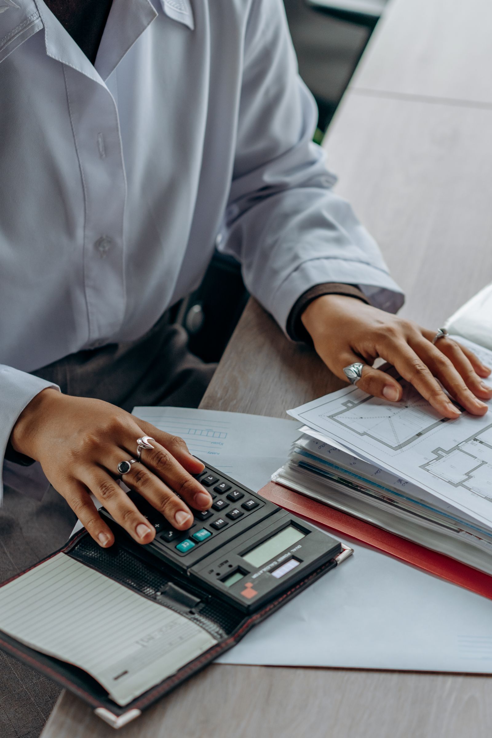 Professional reviewing payroll and financial planning documents with a calculator